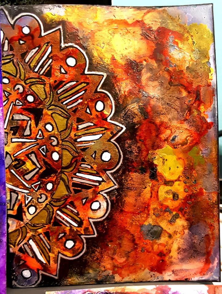 Red, orange, and yellow alcohol inks on yupo paper with the striped mandala stencil outlined in black, gold, white, and silver Signo uni-ball pens. Black stabilio all pencil has been shaded around the outside of the stencil to give a shadow effect.